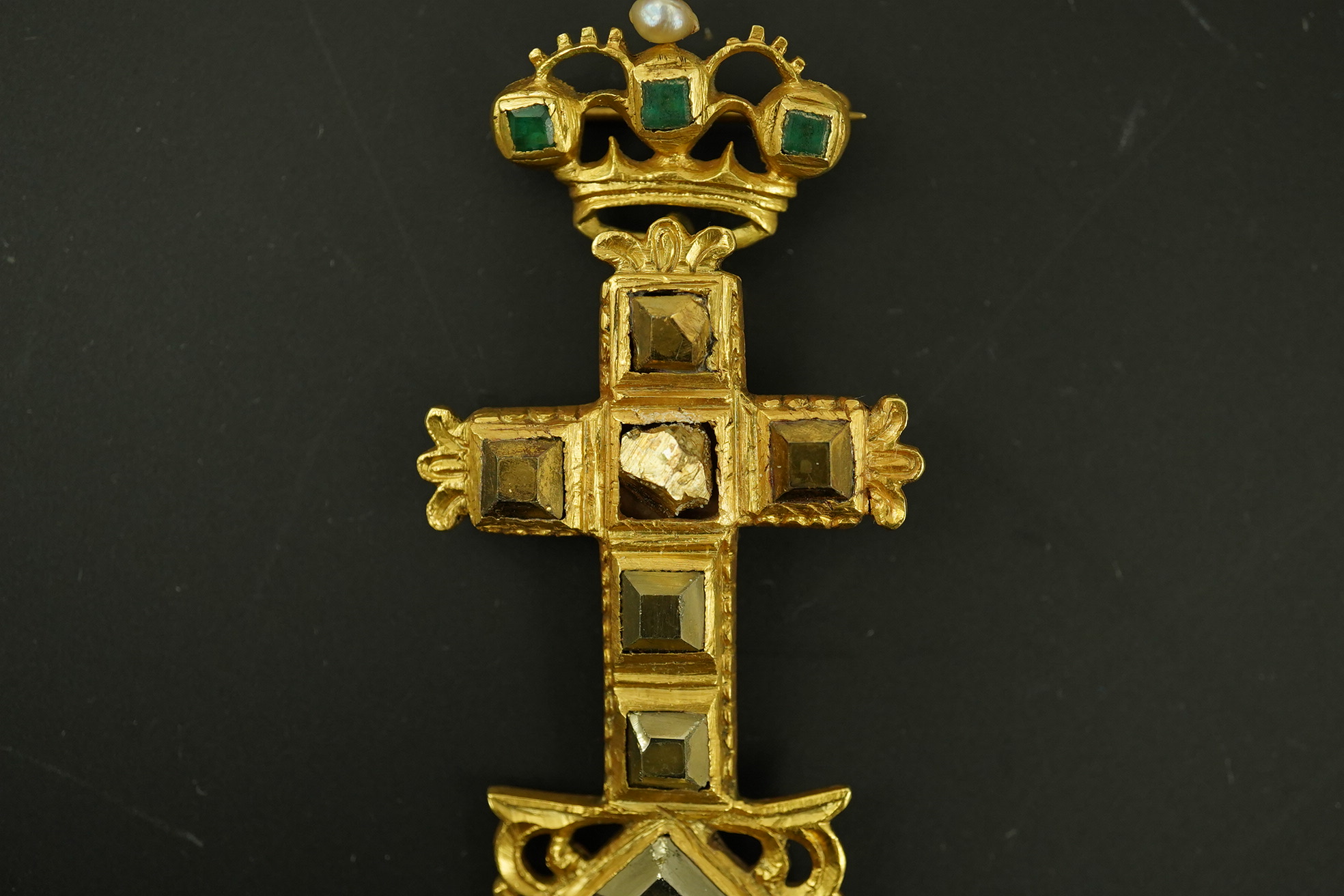 An antique continental engraved gold and seven stone pyrites? set cross pendant, with a gold, emerald and seed pearl set suspension brooch attachment